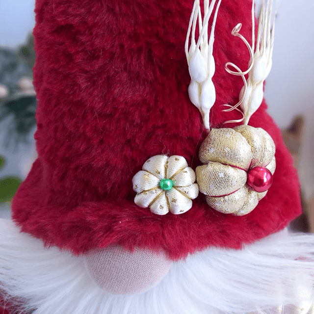 Tomte lutin de Noël au bonnet rouge et citrouilles dorées