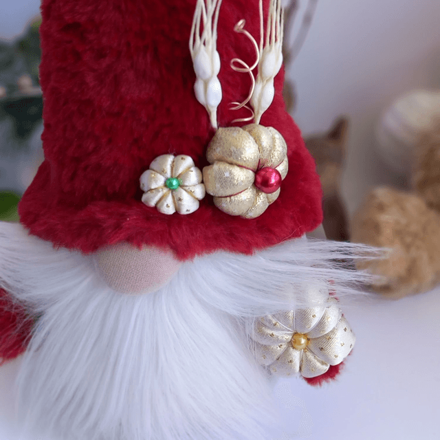 Tomte lutin de Noël au bonnet rouge et citrouilles dorées