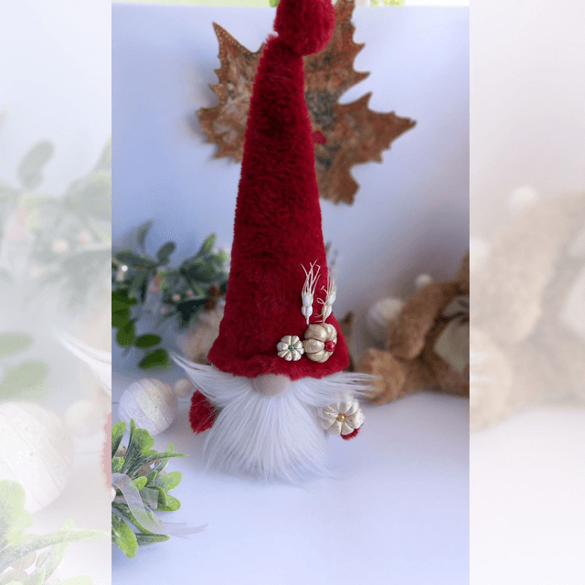 Tomte lutin de Noël au bonnet rouge et citrouilles dorées